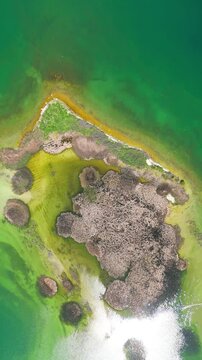 Scenic aerial drone image of a  island surrounded by white sand coastline. Chayei Island, Sevan, Armenia