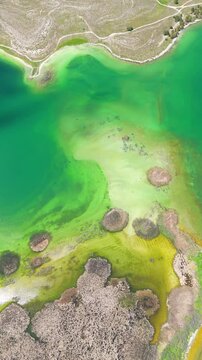 Scenic aerial drone image of a  island surrounded by white sand coastline. Chayei Island, Sevan, Armenia