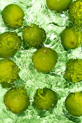 Green Limes on Water Surface Flat Lay Vertical