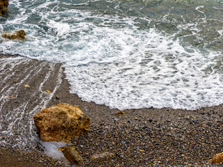 Waves lap Kalo Nero's rocky shore