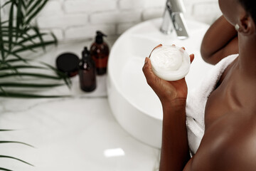 Self-care routine with cream in a cozy bathroom setting featuring natural elements and a focus on wellness