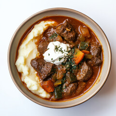 A bowl of Ethiopian-inspired stew with spicy berbere sauce over mashed potatoes, blending bold flavors with a French-style creamy touch and creme fraeche topping.