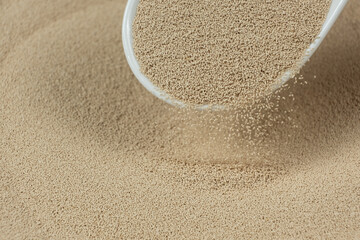 Dry yeast is poured out of a spoon