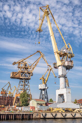 Large cranes working in the shipyard. Industrial landscape..