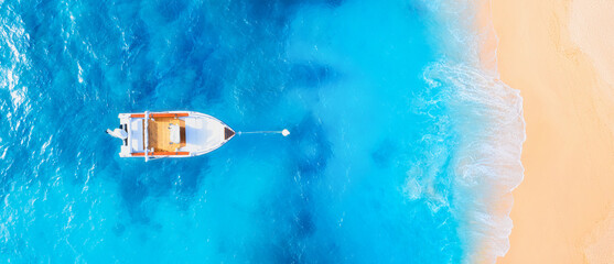 Drone view of the motor boat. Marine transport. Beach and waves. Vacation and holidays. Aerial landscape. Summer time for sea travel. The sea bay. Background, wallpaper, postcard.