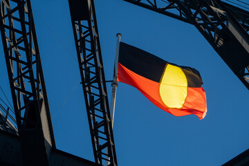 Aboriginal Australian Flag Flying from Sydney Harbour Bridge Steel Structure Against Blue Sky