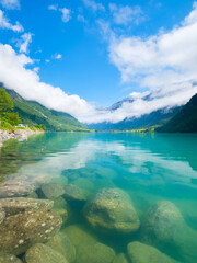 Norway. Nature in fjords. High mountains and reflections on the surface of the water. Scandinavia. Vacation and travel in summer Norway. Wallpaper, postcard, background.