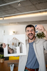Fototapeta premium Real estate agent holding keys and house symbol showing new property