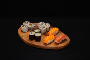Wooden Platter With Assorted Sushi Rolls on Dark Background
