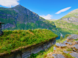 Geiranger Fjord, Norway. Nature in fjords. Traveling on a Norwegian fjord. Scandinavia. Traditional old settlement. Houses with moss on the roof.