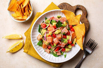 Top view of salmon ceviche, a fish dish, salmon marinated in citrus and seasonings, avocado, tomato...
