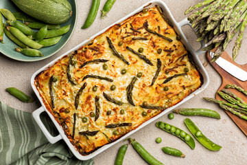 Baking tray with Spring Vegetable Lasagna - Lasagne primavera, with asparagus, peas, zucchini and aged ricotta cheese.