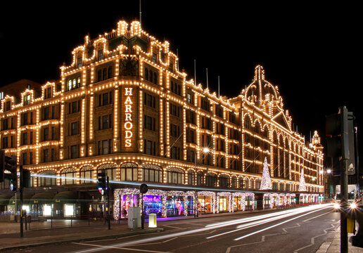 Long exposure shot of Harrods department store in London during night with street traffic