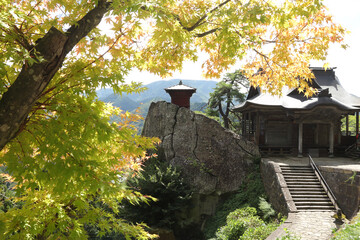 Yamadera temple at the beginning of fall with yellow maple leafs