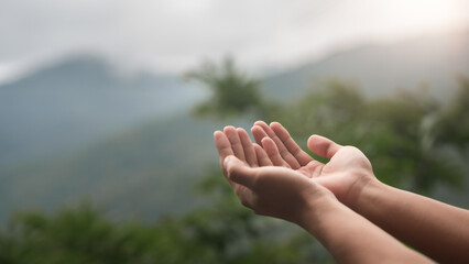 Hands lifted in Christian prayer, expressing faith, hope, and spiritual connection with God. Peaceful moment in nature, symbolizing devotion, trust, and inner calm through religious belief.