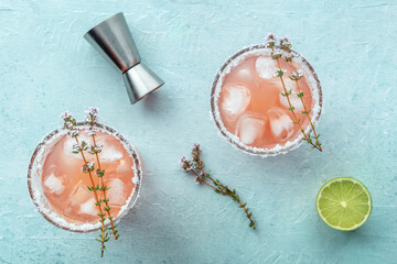 Salty Dog cocktail with fresh grapefruit juice, lime juice, and thyme, overhead flat lay shot with a jigger