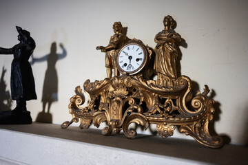 Ornate antique clock with golden details and classical sculptures on display