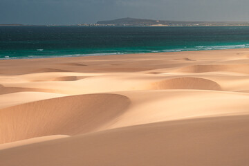 Sweeping sand dunes meet the turquoise waters of the Atlantic Ocean on Boa Vista Island, Cape Verde – a stunning fusion of desert and sea in a tropical paradise