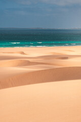 Sweeping sand dunes meet the turquoise waters of the Atlantic Ocean on Boa Vista Island, Cape Verde – a stunning fusion of desert and sea in a tropical paradise