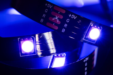 RGB led strip light on metallic background illumination in blue color, electric devise