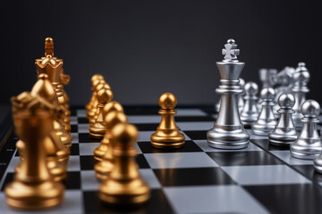 King silver chess standing confront of the golden chess team.