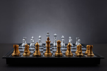chessboard with chess pieces ready for the game on dark background
