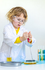 Laboratory examination of a child with test tubes, reagents and a microscope. Selective focus.