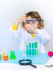 Laboratory examination of a child with test tubes, reagents and a microscope. Selective focus.
