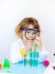 Laboratory examination of a child with test tubes, reagents and a microscope. Selective focus.