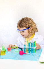 Laboratory examination of a child with test tubes, reagents and a microscope. Selective focus.
