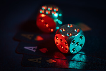 three aces cards and two dice on a dark background
