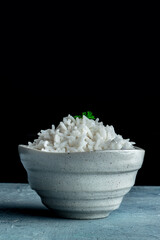 White rice, cooked. A bowl of boiled long grain rice, a simple side dish, side view with a place for text