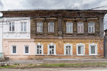 An old 1898 two-story apartment building in Provincetown where the lower floor is brick and the upper floor is wood.