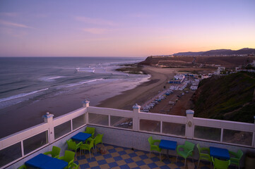Sunset view over Sidi Ifni beach showcasing vibrant outdoor seating and coastline