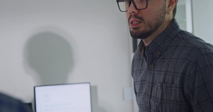 Closeup team adult male engineer collaborate on robotic hand project using AI code solutions machine learning at tech workspace. Artificial intelligence interface, collaboration prototype development.