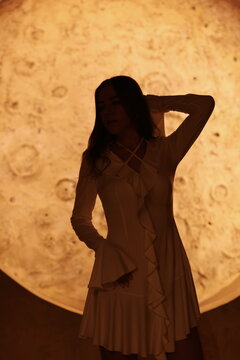 Fototapeta Silhouette Model Standing Gracefully Against a Stunning Moonlight Background, Evoking Emotions