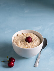 Porridge bowl with fresh fruit isolated on blue background. Healthy and vegan breakfast