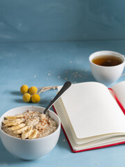 Personal writing moment while enjoying a healthy breakfast. Blue background and dried flowers on the background