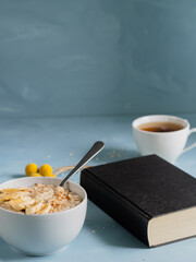 Relaxing reading time during breakfast. Book with some dried flowers and a healthy breakfast