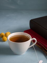 Relaxing reading time during breakfast. Books and dried flowers next to a cup of hot tea