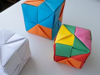 Bright modular origami cubes arranged on a white surface with minimal shadows.