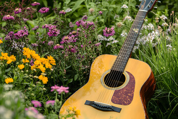Acoustic guitar resting among colorful flowers in a tranquil garden setting
