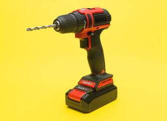 cordless screwdriver with a drill bit on a yellow background