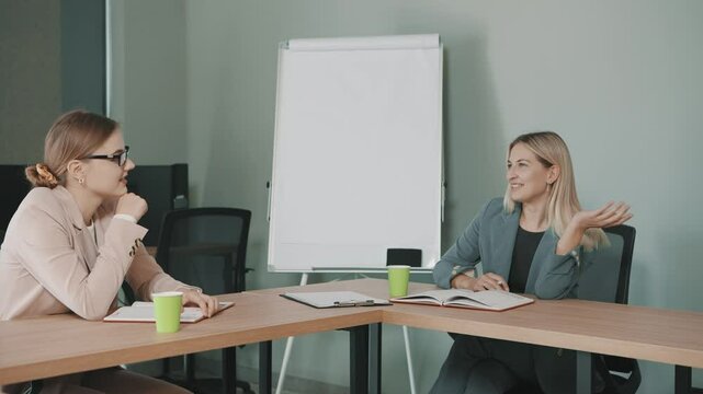 Business meeting between two professionals discussing a project in a modern office environment with documents