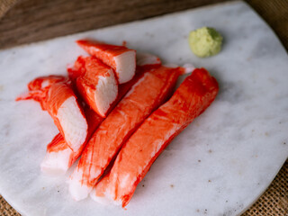 Fresh crab sticks surimi set on white plate with wasibi.