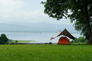 A camping site in a natural area in the middle of a forest and a stream.