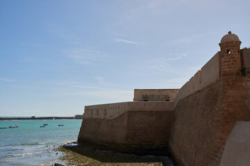 Santa Catalina Castle in Cádiz, Spain, with stone walls by the turquoise sea © EvaMara