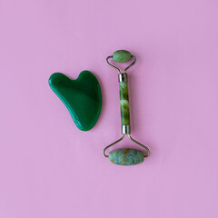 Jade massagers on a pink background. Square background.