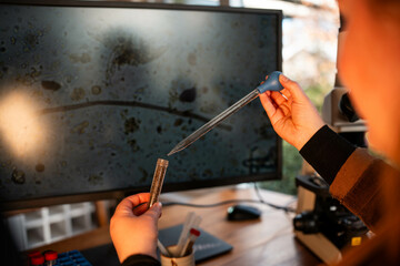 Home lab testing soil samples for soil life biology microorganisms in compost with a microscope,...