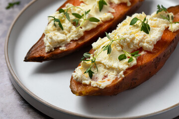 Baked sweet potatoes with ricotta and fresh herbs. Healthy and vegan food